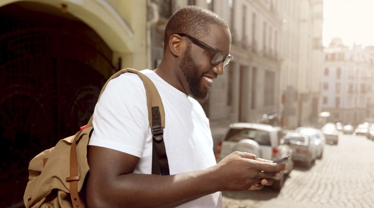 Happy African American man outside on phone