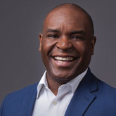 A professional headshot of Kirk McDonald