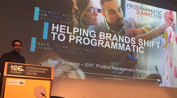 A man standing in front of a podium speaking in front of an audience