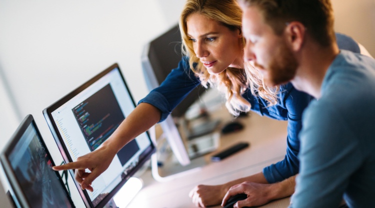 A man and woman looking at a monitor placed in front of them