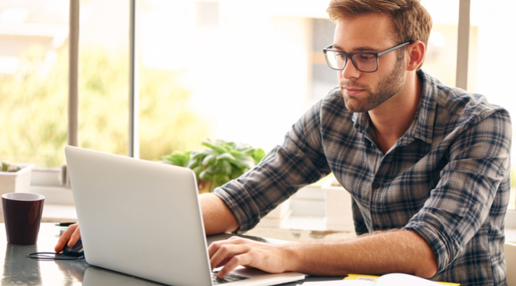A man working on his laptop while seated in an office