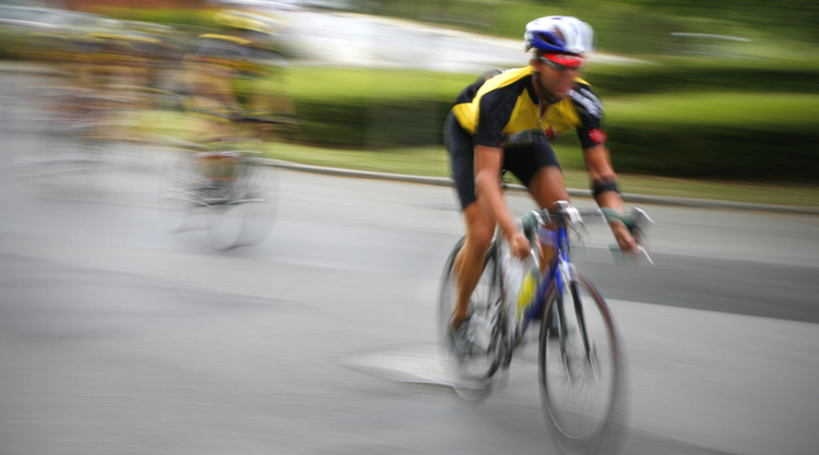 A man on a bike cycling in the road