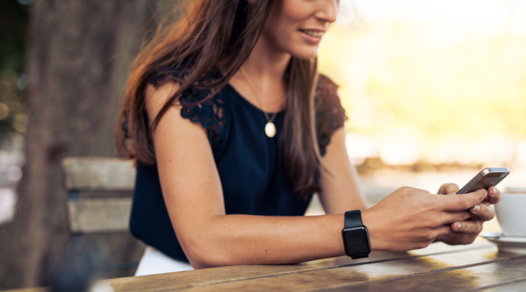 A woman using her cell phone while seated outside