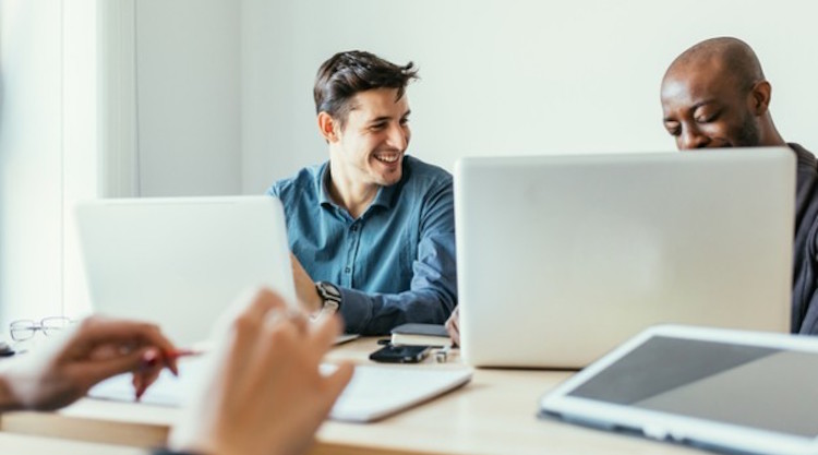 Two men working on their laptops in an office