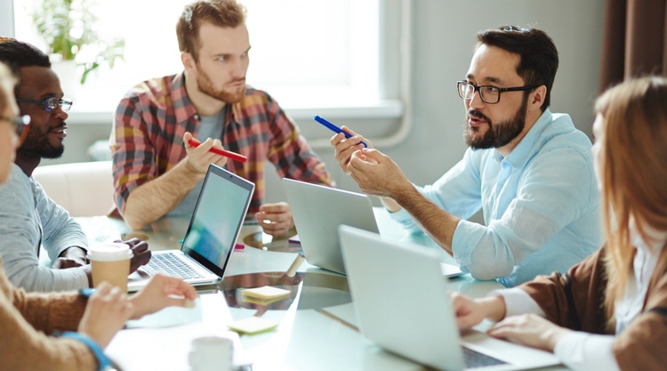 A team of coworkers at a conference table working with each other