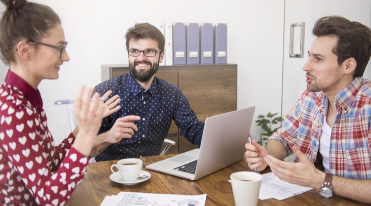 A group of coworkers sitting in their office working together