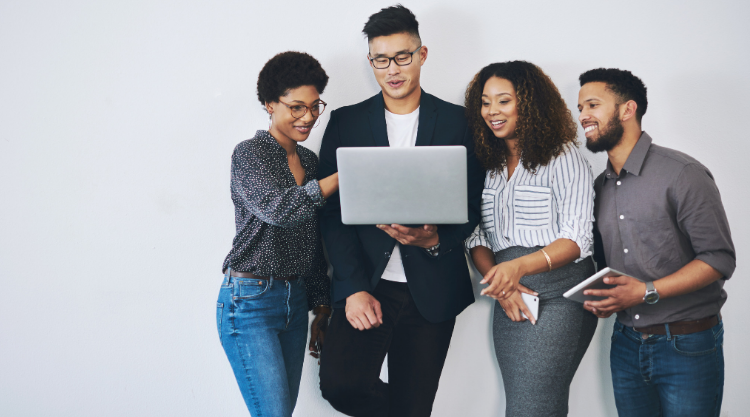 A group of young professionals standing against a white wall.
