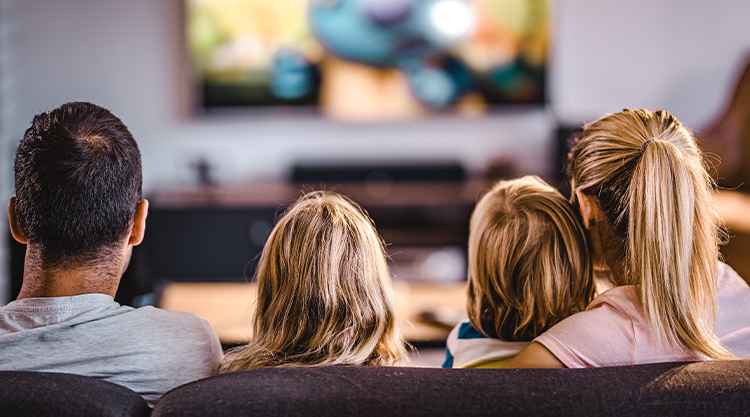 A family of four sitting in their living room.