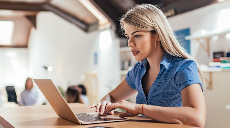 A young woman working on her laptop in a cafe.
