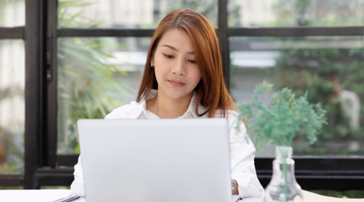 A young woman working on her laptop in an office