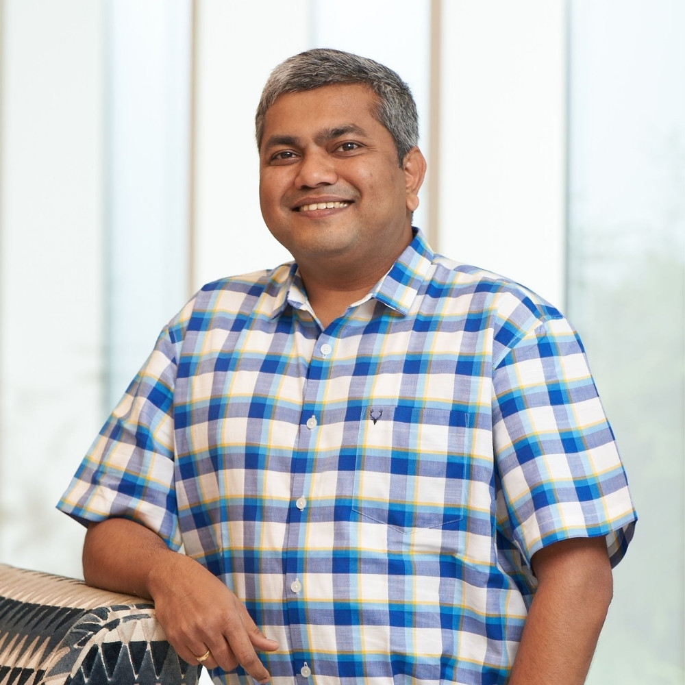 Smiling adult man standing in front of a light green gradient background