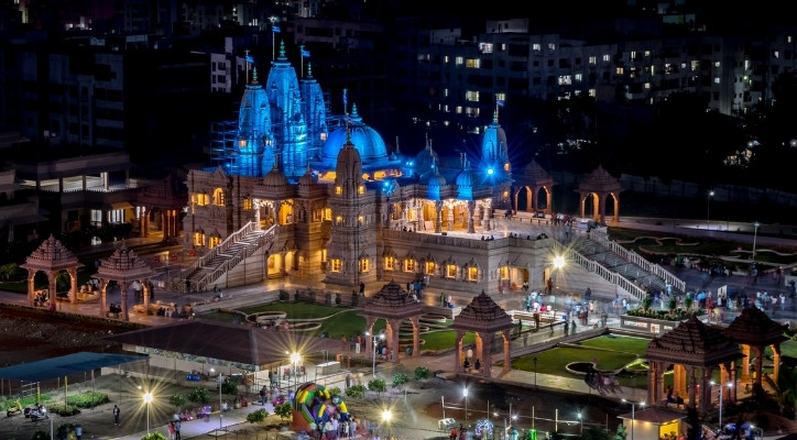 The city of Pune at night. The building of covered in blue and yellow lights.