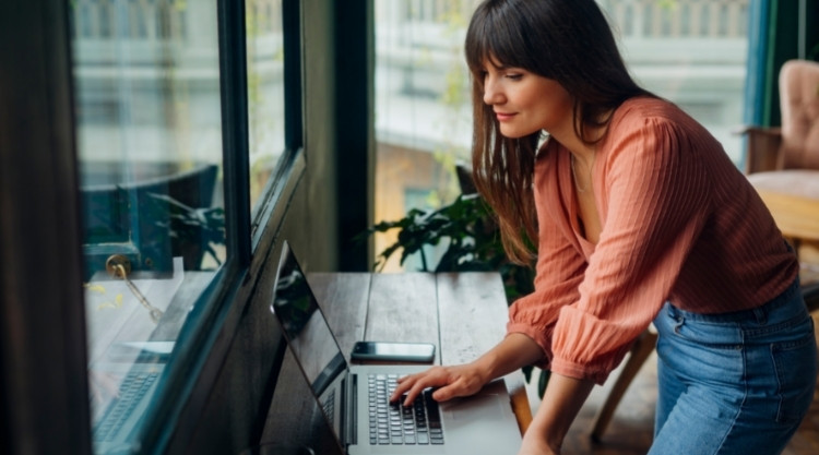 Woman working from home looking at a laptop