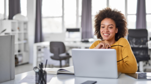 Young woman smiling while looking at laptop in an office