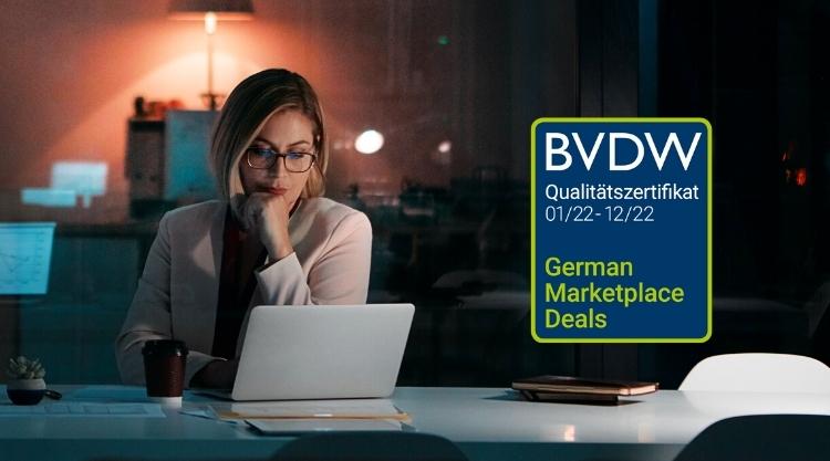 An adult woman is sitting in her office space while using her laptop. The text 