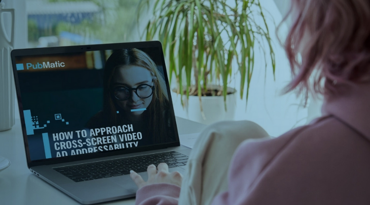A woman sitting down on her laptop with a woman on the screen and the text "How to approach cross-screen video AD Addressability"