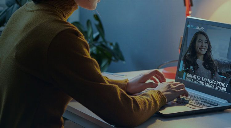 Person in a yellow long sleeve shirt, on a laptop looking at a report with the text "Greater Transparency will bring more spend"