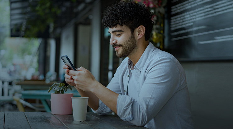 An adult man staring pensively at a laptop screen in an office