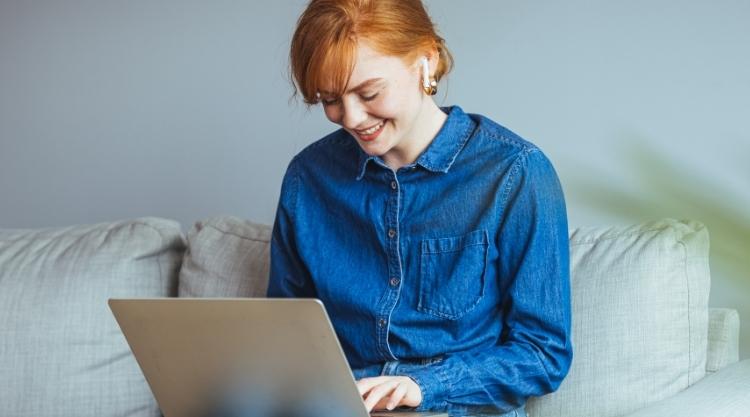 Happy businesswoman professional worker working online doing job on laptop at sofa