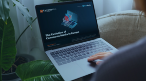 A person using their laptop with an image of a shopping cart on top of a laptop with the text " The Evolution of Commerce Media in Europe" below it