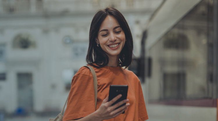 Woman smiling while looking at phone