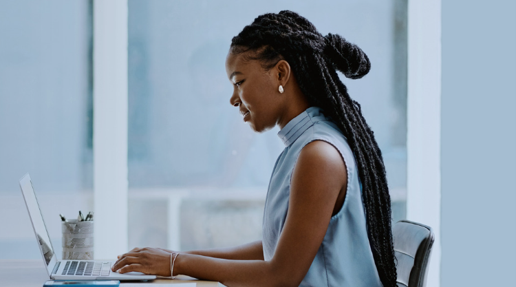 Young black woman smiling while working on her laptop