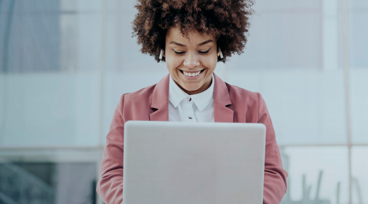 Business woman wearing formal clothes sitting outdoors in business area and using her computer