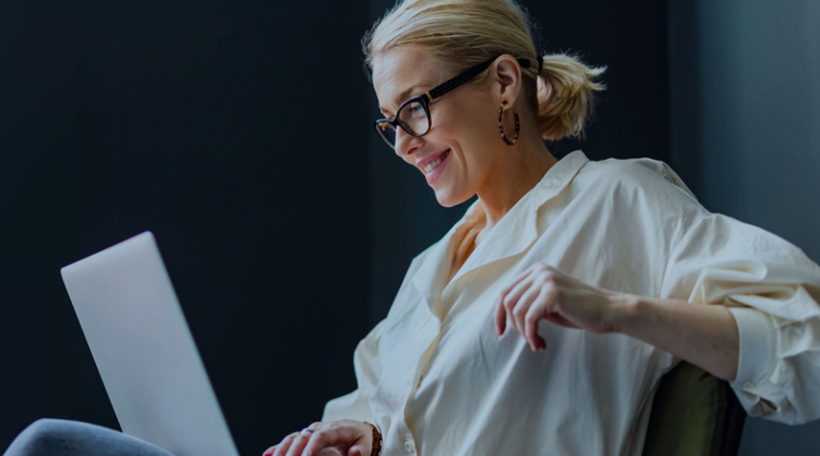 Woman looking at laptop while smiling