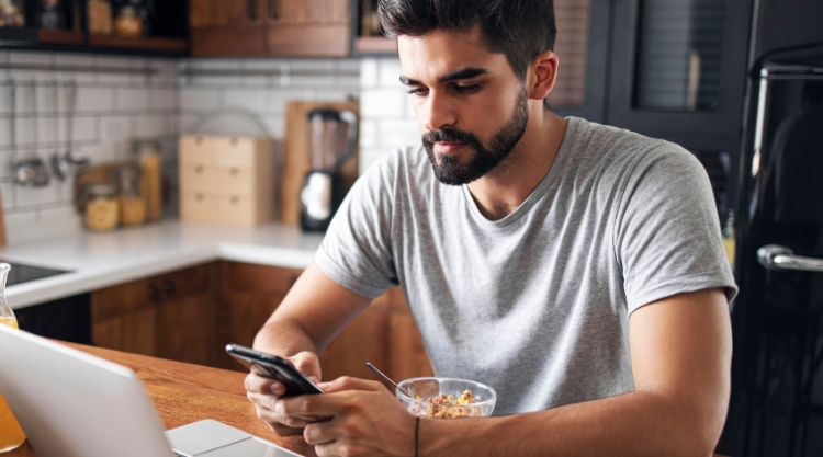 A bearded man uses his mobile device