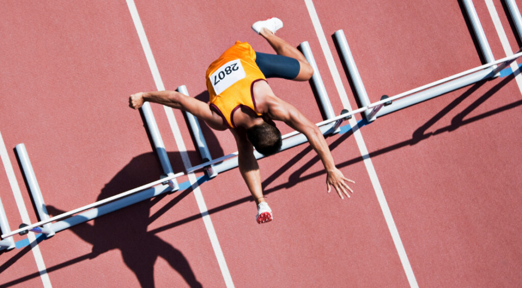 Runner jumping hurdles on track