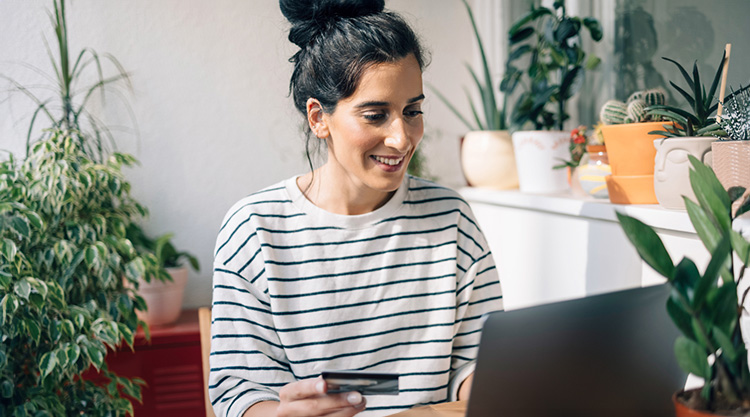 A woman uses her credit card to make an online purchase